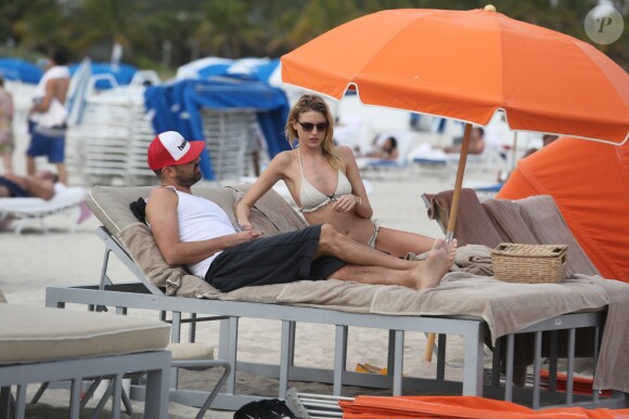 Le top model Martha Hunt et un ami se détendent sur une plage de South Beach, à Miami. Le 21 décembre 2014.