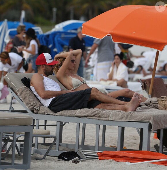 Le top model Martha Hunt et un ami se détendent sur une plage de South Beach, à Miami. Le 21 décembre 2014.