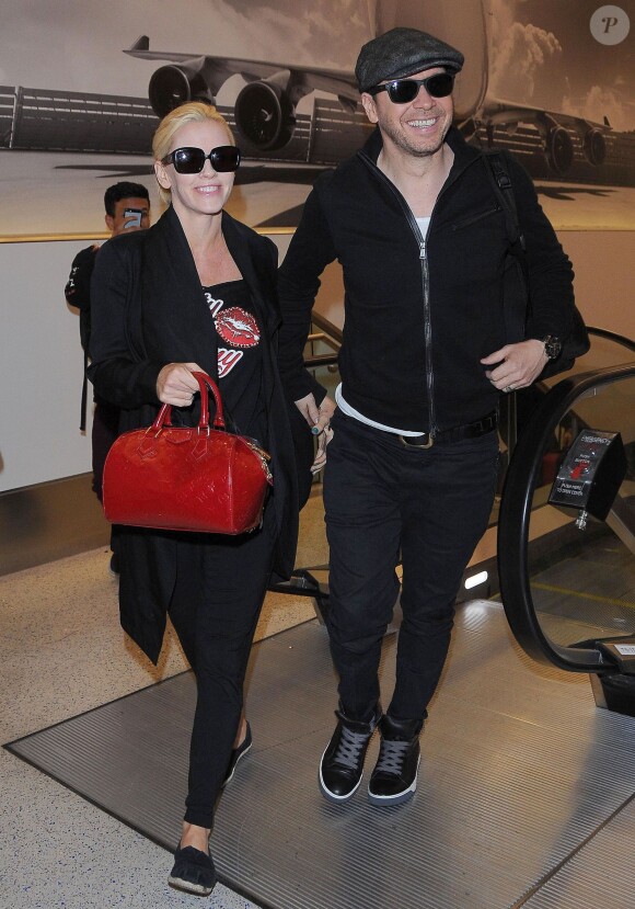 Jenny McCarthy et son mari Donnie Walhberg prennent un vol à l'aéroport de Los Angeles, le 28 septembre 2014. 