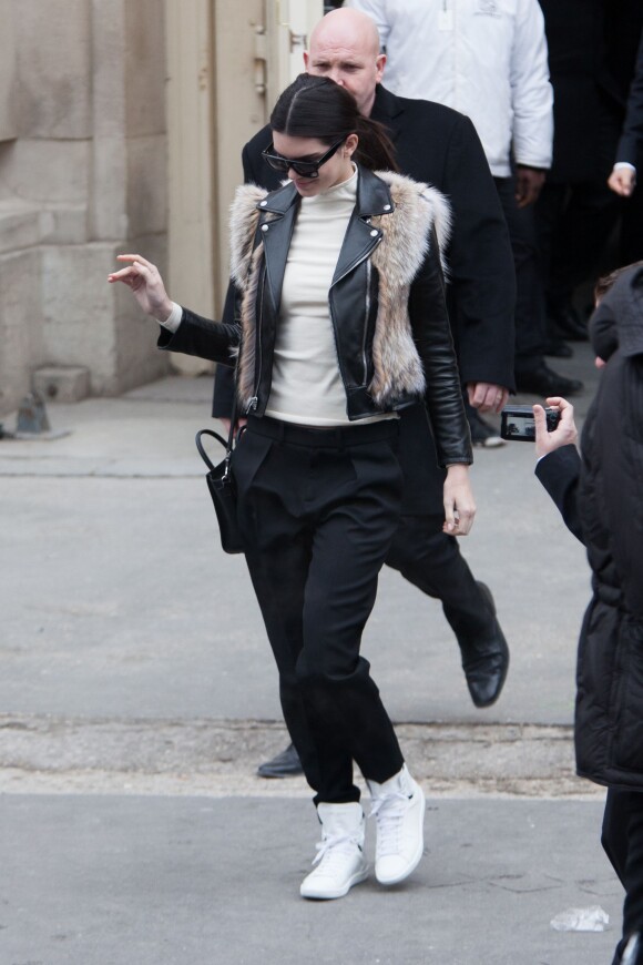 Kendall Jenner quitte le Grand Palais à l'issue du défilé Chanel haute couture. Elle porte une veste en cuir et fourrure et des baskets Saint Laurent, un top crème, un sac Céline et un pantalon noirs. Paris, le 27 janvier 2015.