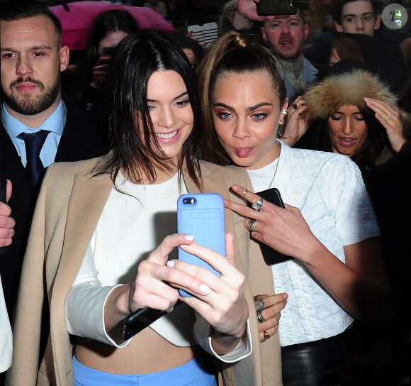 Pause selfie pour Kendall Jenner et Cara Delevingne à leur arrivée au défilé Topshop Unique automne-hiver 2015-2016, au musée Tate Britain. Londres, le 22 février 2015.