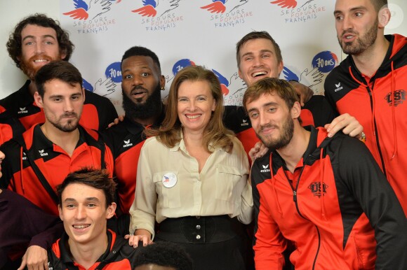 Valérie Trierweiler et l'équipe de Handball d'Ivry-sur-Seine lors du début de la tournée des "Pères Noël verts" 2014 à l'occasion des 70 ans du Secours populaire au Palais de l'Unesco à Paris le 8 décembre 2014