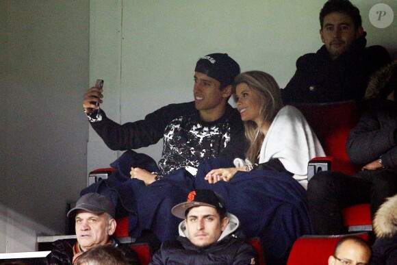 Marquinhos et sa belle fiancée Carol Cabrino font un selfie lors du match de Ligue 1 entre le PSG et Lorient au Parc des Princes à Paris, le 20 mars 2015