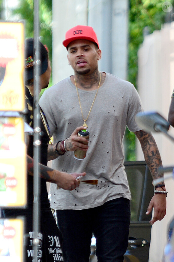Chris Brown tague un mur avec un ami dans les rues de Miami, le 27 octobre 2014. 