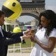 Serena Williams se voit remettre par Christophe Beaugrand une petite statuette la représentant façon blocs en 3D sur le Champs-de-Mars à Paris dans le cadre d'une opération de promotion pour le film Pixels dans lequel elle fait une apparition au côté du légendaire Pac-Man, le 22 mai 2015
