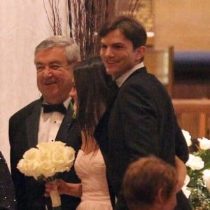 Mila Kunis entre son père, Mark Kunis et son petit ami Ashton Kutcher au mariage de son frere aîné, Michael, avec la danseuse Alexandra Blacker à St Petersbourg en Floride, le 7 décembre 2013.