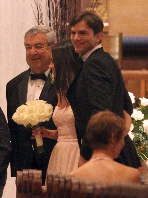 Mila Kunis entre son père, Mark Kunis et son petit ami Ashton Kutcher au mariage de son frere aîné, Michael, avec la danseuse Alexandra Blacker à St Petersbourg en Floride, le 7 décembre 2013.