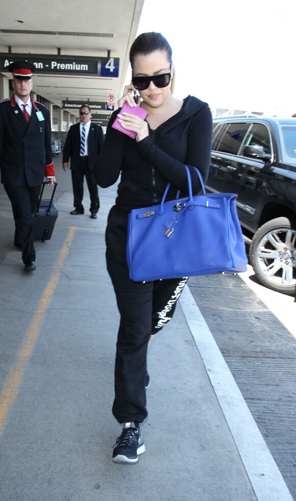 Khloé Kardashian prend un vol à l'aéroport de LAX à Los Angeles, le 13 juillet 2014. Elle porte un sac de la marque Hermès. Khloé Kardashian a évoqué pour la première fois à cœur ouvert les multiples infidélités de Lamar Odom. 