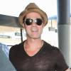 Brad Pitt dévoile ses muscles à cause des flashs, à l'aéroport de Los Angeles, le 26 juillet 2015.