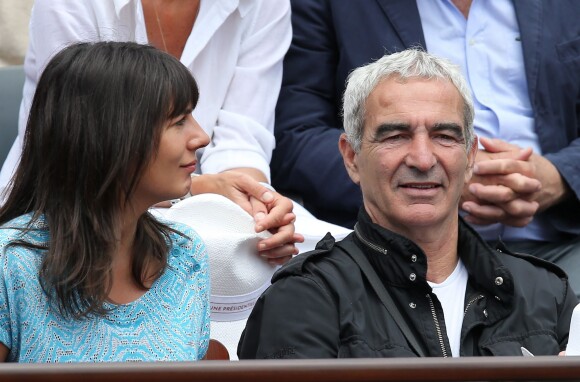 Raymond Domenech et sa compagne Estelle Denis dans les tribunes du tournoi de tennis de Roland Garros à Paris le 1er juin 2015.