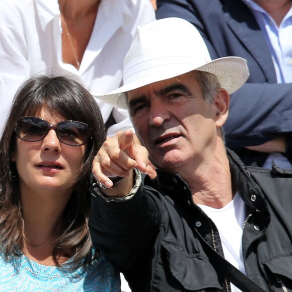 Raymond Domenech et sa compagne Estelle Denis dans les tribunes du tournoi de tennis de Roland Garros à Paris le 1er juin 2015.