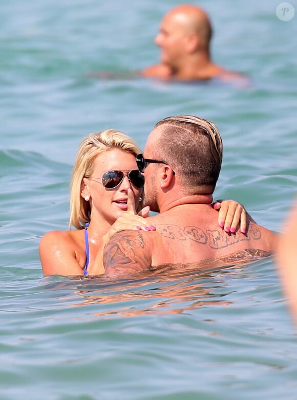 Amélie Neten (Star de SS4 et des Anges de la télé-réalité) et son compagnon Philippe Leonard (ex-footballeur) en vacances à la plage l'Eden à Saint-Tropez le 11 août 2015.