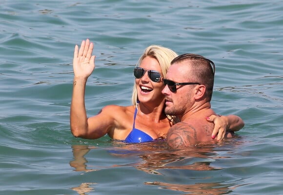 Amélie Neten (Ex-candidate de Secret Story 4 et des Anges de la télé-réalité) et son compagnon Philippe Leonard (ex-footballeur) en vacances à la plage l'Eden à Saint-Tropez le 11 août 2015.