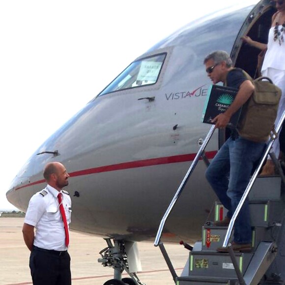 Exclusif - George Clooney et sa femme Amal Alamuddin Clooney débarquent d'un jet à Ibiza en compagnie de Cindy Crawford et son mari Rande Gerber le 22 août 2015. Il descend de l'avion avec un carton de sa Tequila "Casamigos" sous le bras.