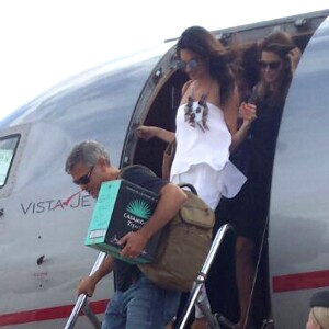 Exclusif - George Clooney et sa femme Amal Alamuddin Clooney débarquent d'un jet à Ibiza en compagnie de Cindy Crawford et son mari Rande Gerber le 22 août 2015. Il descend de l'avion avec un carton de sa Tequila "Casamigos" sous le bras.