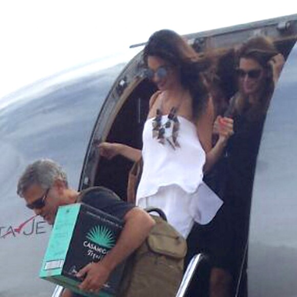 Exclusif - George Clooney et sa femme Amal Alamuddin Clooney débarquent d'un jet à Ibiza en compagnie de Cindy Crawford et son mari Rande Gerber le 22 août 2015. Il descend de l'avion avec un carton de sa Tequila "Casamigos" sous le bras.