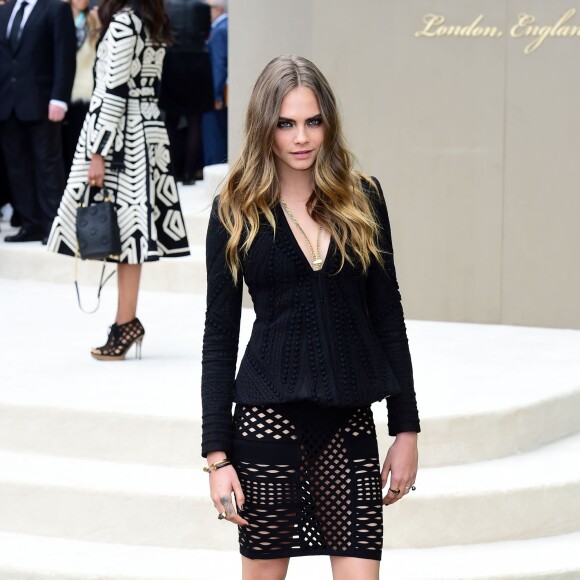 Cara Delevingne assiste au défilé Burberry Prorsum (collection printemps-été 2016) à Hyde Park. Londres, le 21 septembre 2015.