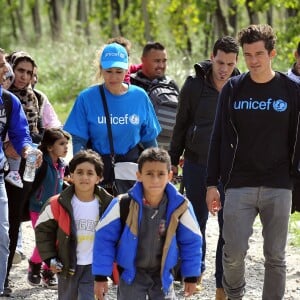 Orlando Bloom, ambassadeur de l'UNICEF, marche avec des enfants et des adultes le long d'un chemin de fer près d'un centre d'accueil pour réfugiés et migrants près de la ville de Gevgelija en Macédoine à la frontière avec la Grèce le 29 septembre 2015.