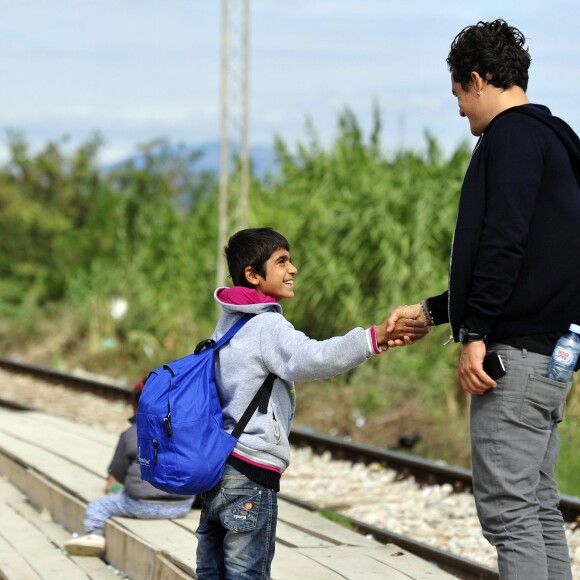 Orlando Bloom, ambassadeur de l'UNICEF, marche avec des enfants et des adultes le long d'un chemin de fer près d'un centre d'accueil pour réfugiés et migrants près de la ville de Gevgelija en Macédoine à la frontière avec la Grèce le 29 septembre 2015.