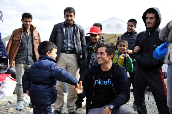 Orlando Bloom, ambassadeur de l'UNICEF, marche avec des enfants et des adultes le long d'un chemin de fer près d'un centre d'accueil pour réfugiés et migrants près de la ville de Gevgelija en Macédoine à la frontière avec la Grèce le 29 septembre 2015.