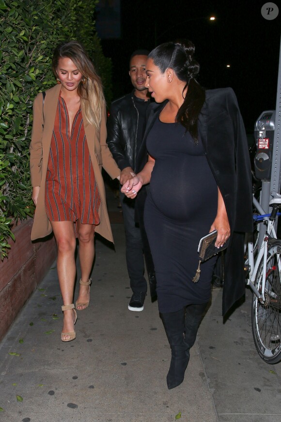 Chrissy Teigen, enceinte et de sortie avec son mari John Legend et Kim Kardashian, porte un manteau beige, une robe-chemise By Marlene Birger, un sac Chloé et des sandales Givenchy. Santa Monica, le 21 novembre 2015.