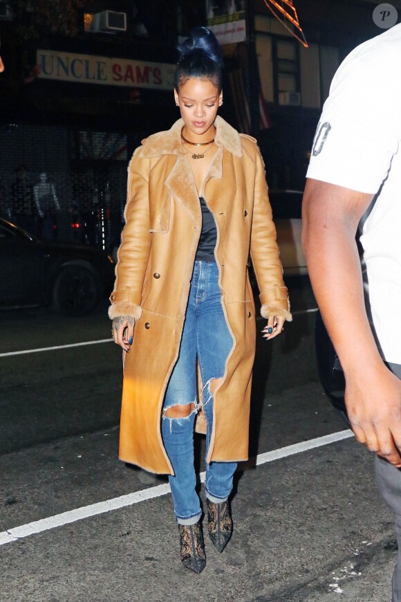 Rihanna de sortie à New York, porte un manteau camel en cuir Chanel, un top noir en satin, un jean Citizens of Humanity et des bottines en dentelle Christian Dior. Le 21 novembre 2015.