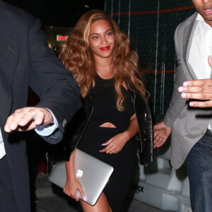 Beyonce Knowles, un MacBook Apple à la main, lors d'une sortie de nuit à New York, le 30 juin 2015.