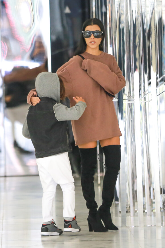 Kourtney Kardashian fait du shopping au magasin Saint Laurent avec son fils Mason, habillée d'un pull YEEZY x adidas Originals (collection Season 1), d'un sac Givenchy (modèle Pandora Box) et des bottes Stuart Weitzman. Beverly Hills, le 30 novembre 2015.