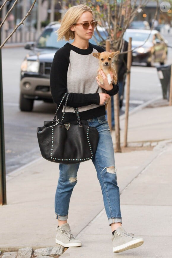 Jennifer Lawrence arrive à l'hôtel Greenwich à New York, habillée d'un pull et de baskets rag & bone, d'un jean AG et d'un sac Valentino (modèle Rockstud). Le 27 novembre 2015.