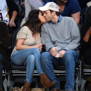 Mila Kunis et son fiancé Ashton Kutcher très amoureux et très complices au match de basket des Lakers à Oklahoma City, le 19 décembre 2014.