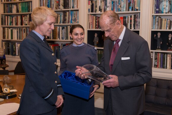 Kate Middleton, duchesse de Cambridge, a hérité du patronage de la Air Cadet Organisation (les Cadets de l'Air de la RAF) qu'a assumé le prince Philip - recevant ici un cadeau de départ - pendant 63 ans. Le passage de témoin a eu lieu le 16 décembre 2015 à Buckingham Palace en marge du déjeuner de Noël organisé par la reine Elizabeth II.