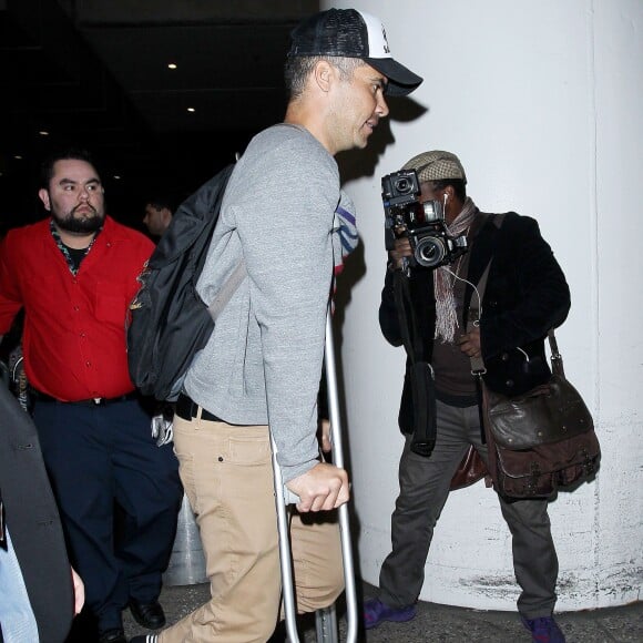 Jessica Alba à l'aéroport de Lax avec ses filles Honor et Haven ainsi que son mari Cash Warren qui marche avec des béquilles à Los Angeles le 2 janvier 2016.