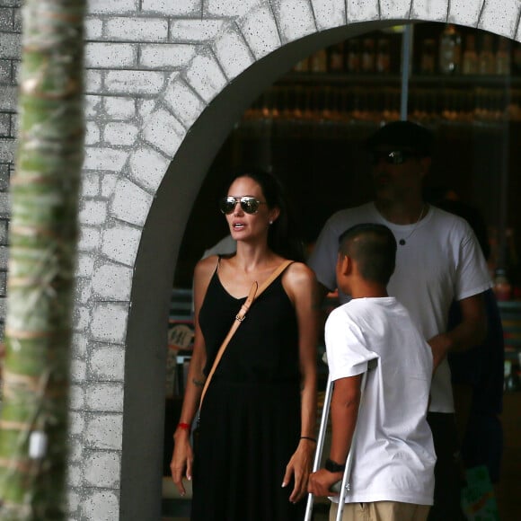 Exclusif - Angelina Jolie, son frère James Haven, et ses enfants Pax (en béquilles à cause de sa jambe cassée suite à son accident de jet-ski) et Maddox Jolie-Pitt font du shopping dans un centre commercial à Phuket. À la sortie du centre commercial, se trouve la porte d'un temple hindou devant laquelle Angelina s'est arrêtée pour prier et se recueillir avec sa famille, le 27 décembre 2015.