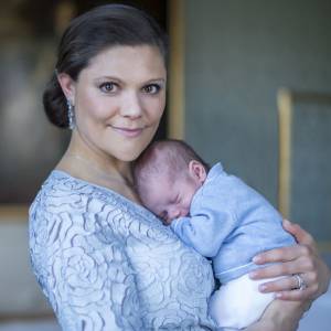 La princesse Victoria de Suède tenant le prince Oscar dans ses bras, photo réalisée par Kate Gabor et publiée par la cour royale de Suède le 24 mars 2016, soit trois semaines après la naissance du bébé.