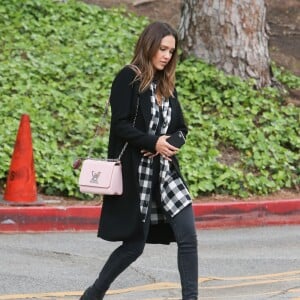 Jessica Alba se rend à un évènement avec une amie à l'université UCLA à Los Angeles, habillée d'un cardigan noir, d'une chemise à carreaux en coton Cynjin, d'un jean DL1961 et de chaussures noires. Un sac rose Louis Vuitton (modèle Twist) accessoirise sa tenue. Le 5 mai 2016.