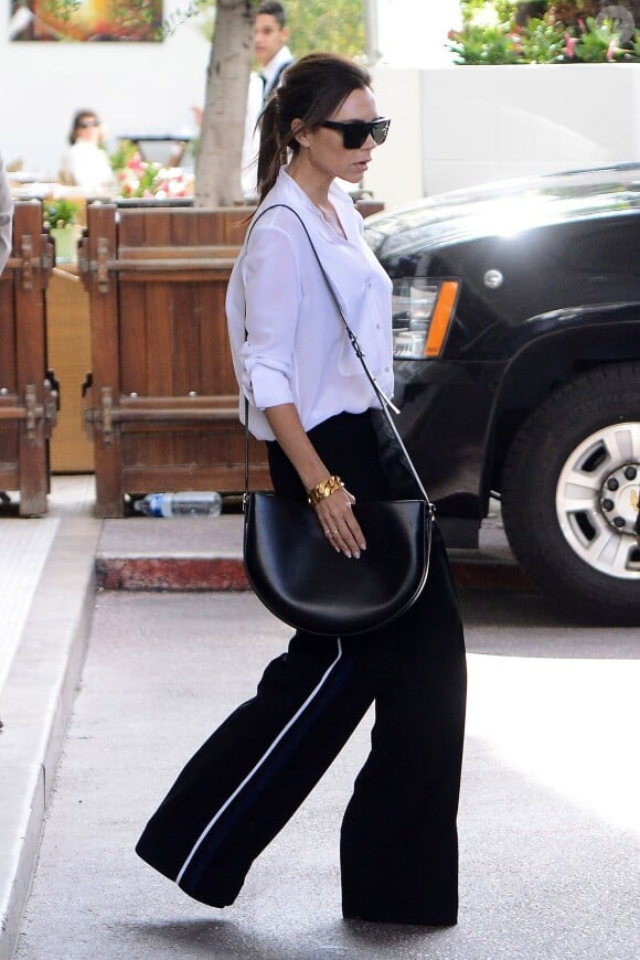 Victoria Beckham quitte l'hôtel Martinez à Cannes, toute de Victoria Beckham vêtue et tenant un sac Half Moon (Demi Lune, collection printemps-été 2016). Le 12 mai 2016.