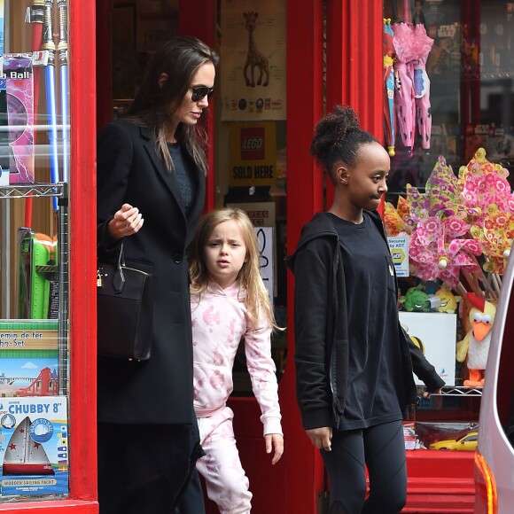 Brad Pitt, sa femme Angelina Jolie et leurs filles Vivienne et Zahara quittent un magasin de jouets à Londres le 12 mars 2016