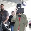 Ruby Rose se cache derrière son sac Yves Saint Laurent à son arrivée à l'aéroport LAX de Los Angeles. Le 13 mai 2016