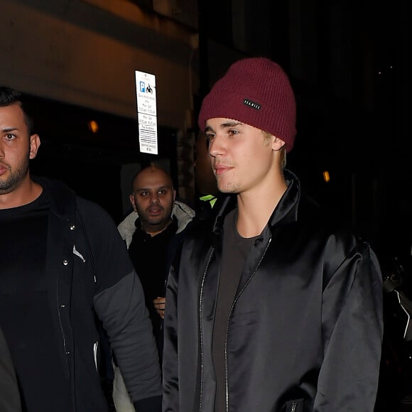 Justin Bieber, escorté par ses gardes du corps, traverse une foule de fans pour se rendre au bar "The Crow" avant d'aller faire la fête à la boîte de nuit "Tape" après la cérémonie des Brit Awards à Londres, le 24 février 2016.