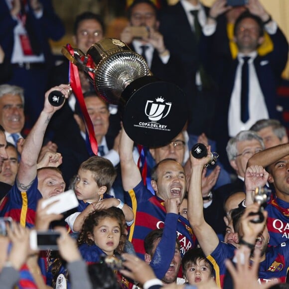 Andres Iniesta, Lionel Messi et son fils Mateo et les joueurs du Barça célèbrent leur victoire (2-0 après prolongations) lors de la finale de la Coupe du Roi entre le FC Barcelone et le FC Séville à Vicente Calderon à Madrid en Espagne le 22 mai 2016.