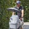 Le prince Carl Philip de Suède promène son fils le prince Alexander pendant que la princesse Sofia assiste à un séminaire à Bastad, la ville où ils se sont connus, le 4 août 2016. Il est accompagné d'un garde du corps qui promène le chien de la famille, Siri.