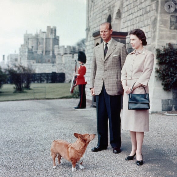 La reine Elizabeth II et le duc d'Edimbourg avec l'un de leurs corgis, Sugar, en juin 1959 à Windsor.