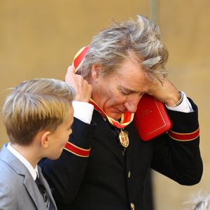 Sir Rod Stewart montre fièrement sa médaille après sa remise de décoration à Buckingham Palace à Londres le 11 octobre 2016. Le chanteur était accompagné de son épouse Penny Lancaster et leurs enfants, Alastair et Aiden.
