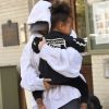 Kim Kardashian, cachée par ses vêtements, et sa fille North sortent de son appartement à New York, le 6 octobre 2016.