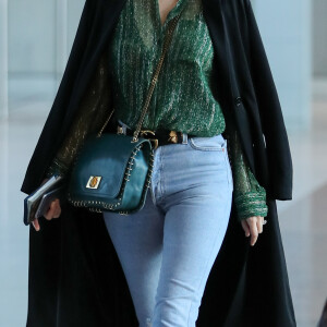 Miranda Kerr arrive à l'aéroport de Paris-Charles-de-Gaulle à Roissy-en-France, près de Paris, le 4 octobre 2016, pendant la fashion week pour se rendre à un rendez-vous.