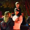 Exclusif - Hilary Duff embrasse son compagnon Jason Walsh (qui porte son fils Luca sur ses épaules!) à la sortie d'un marché à Los Angeles, le 31 octobre 2016. 