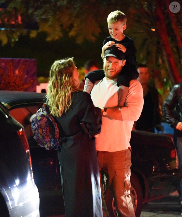 Exclusif - Hilary Duff embrasse son compagnon Jason Walsh (qui porte son fils Luca sur ses épaules!) à la sortie d'un marché à Los Angeles, le 31 octobre 2016. 