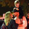 Exclusif - Hilary Duff embrasse son compagnon Jason Walsh (qui porte son fils Luca sur ses épaules!) à la sortie d'un marché à Los Angeles, le 31 octobre 2016. 
