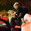 Exclusif - Hilary Duff embrasse son compagnon Jason Walsh (qui porte son fils Luca sur ses épaules!) à la sortie d'un marché à Los Angeles, le 31 octobre 2016. 