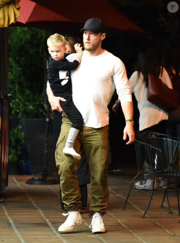 Exclusif - Hilary Duff embrasse son compagnon Jason Walsh (qui porte son fils Luca sur ses épaules!) à la sortie d'un marché à Los Angeles, le 31 octobre 2016. 